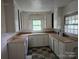 Galley kitchen featuring vintage checkerboard flooring and plenty of cabinet space at 6407 Market St, Charlotte, NC 28215