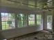 Bright sun room with beadboard paneling, and multiple windows overlooking the backyard at 6407 Market St, Charlotte, NC 28215