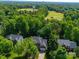 Overhead shot showcasing a neighborhood nestled among trees, adjacent to a golf course with a serene pond at 7006 Olde Sycamore Dr, Mint Hill, NC 28227