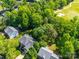 Aerial view of a home surrounded by lush green trees, near a well-maintained golf course at 7006 Olde Sycamore Dr, Mint Hill, NC 28227