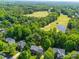Aerial view of homes near a golf course, with mature trees and a pond, blending nature and community at 7006 Olde Sycamore Dr, Mint Hill, NC 28227