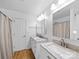 Bright, updated bathroom featuring double sinks with granite countertops, a door, and modern fixtures at 7006 Olde Sycamore Dr, Mint Hill, NC 28227