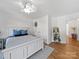 Bright bedroom with hardwood floors, natural light, and neutral walls leading to a hall and bathroom at 7006 Olde Sycamore Dr, Mint Hill, NC 28227