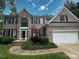 Charming two-story brick home with a well-manicured lawn and attached two-car garage at 7006 Olde Sycamore Dr, Mint Hill, NC 28227