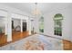 Spacious living room with a chandelier, columns and large windows overlooking a garden at 7006 Olde Sycamore Dr, Mint Hill, NC 28227
