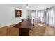 Spacious office with large windows, a large desk, hardwood floors, and a seating area with natural light at 7006 Olde Sycamore Dr, Mint Hill, NC 28227