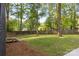 A spacious backyard with mature trees and a wooden fence provides privacy and a peaceful atmosphere at 7416 Cross Tie Ct, Mint Hill, NC 28227