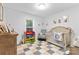 Cozy Bedroom features a crib, checkered floor, colorful toy storage, and cheerful decor at 7416 Cross Tie Ct, Mint Hill, NC 28227
