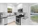 Bright kitchen featuring stainless steel appliances, white cabinetry, and modern lighting at 7416 Cross Tie Ct, Mint Hill, NC 28227