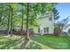 A charming view of the house's backyard featuring a well-kept lawn and a wooden deck, shaded by mature trees at 7600 Ridgefield Dr, Charlotte, NC 28269