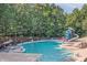 Large community pool with lounge chairs, umbrellas, waterslide and lush green trees in a well-maintained area at 7600 Ridgefield Dr, Charlotte, NC 28269