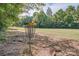 A disc golf basket is surrounded by mature trees and open grassy areas, perfect for outdoor recreation at 7600 Ridgefield Dr, Charlotte, NC 28269