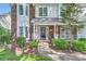 Charming brick home featuring a cozy front porch with a decorative wreath on the front door at 7600 Ridgefield Dr, Charlotte, NC 28269