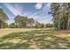 Manicured golf course fairway surrounded by tall trees and lush greenery on a bright, sunny day at 7600 Ridgefield Dr, Charlotte, NC 28269