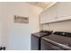 Well-lit laundry room with Samsung washer and dryer and white storage cabinets at 7600 Ridgefield Dr, Charlotte, NC 28269
