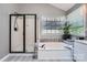 Bright bathroom featuring a shower, soaking tub, and large window with natural light at 7600 Ridgefield Dr, Charlotte, NC 28269