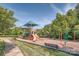 A colorful playground with slides, swings, and climbing structures, set in a well-maintained area with trees at 7600 Ridgefield Dr, Charlotte, NC 28269