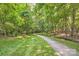 A serene walking path lined with green grass and lush trees for a relaxing outdoor experience at 7600 Ridgefield Dr, Charlotte, NC 28269