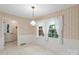 The dining room features vintage wallpaper, classic lighting, and bright windows at 8017 Prince George Rd, Charlotte, NC 28210