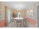 Charming dining room featuring floral wallpaper, a modern chandelier, and a round white table with seating at 8017 Prince George Rd, Charlotte, NC 28210