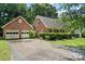Brick home with a spacious two-car garage and ample driveway parking, surrounded by greenery at 8017 Prince George Rd, Charlotte, NC 28210