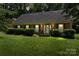 Charming brick home with manicured lawn, shrubbery, and inviting front porch at 8017 Prince George Rd, Charlotte, NC 28210