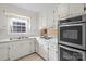A compact kitchen features white cabinets, countertops, and stainless steel appliances at 8017 Prince George Rd, Charlotte, NC 28210