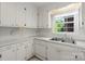 Cozy kitchen features white cabinets, countertops, stainless steel sink, and a bright window at 8017 Prince George Rd, Charlotte, NC 28210