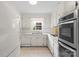 All-white kitchen with modern appliances, tile flooring, and ample counter space for cooking at 8017 Prince George Rd, Charlotte, NC 28210