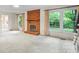 The large, bright living room has a brick fireplace and views of the yard at 8017 Prince George Rd, Charlotte, NC 28210