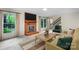 Cozy living room featuring a brick fireplace, staircase, and large windows overlooking greenery at 8017 Prince George Rd, Charlotte, NC 28210