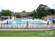 Community pool with chairs and umbrellas, set in landscaped grounds near brick buildings at 8017 Prince George Rd, Charlotte, NC 28210