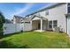 View of the backyard with a covered patio, white fence, green grass, and the rear of the home at 8018 Saluda Dr, Charlotte, NC 28269