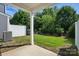 View of the backyard with a covered patio, white fence, green grass, and trees at 8018 Saluda Dr, Charlotte, NC 28269