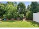 Lush backyard with verdant landscaping next to a white fence at 8018 Saluda Dr, Charlotte, NC 28269