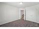 Empty bedroom with gray carpet and a view to a hallway and a closet at 8018 Saluda Dr, Charlotte, NC 28269