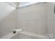 Tiled shower with a built in bench, decor, and horizontal accent tile at 8018 Saluda Dr, Charlotte, NC 28269