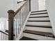 Elegant staircase with dark wood handrail and black wrought iron spindles at 8018 Saluda Dr, Charlotte, NC 28269