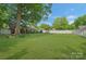 Expansive backyard with lush green grass, mature trees, and a glimpse of the home's exterior at 8206 Idlewild Rd # 22, Indian Trail, NC 28079