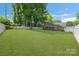 Extensive backyard with a lush lawn, mature trees, a white fence, and an outbuilding at 8206 Idlewild Rd # 22, Indian Trail, NC 28079