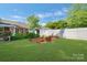 Lush backyard with a white fence, raised garden beds, and a storage shed at 8206 Idlewild Rd # 22, Indian Trail, NC 28079