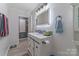 Modern bathroom featuring a white vanity with illuminated mirror and farmhouse-style sliding cabinet doors at 8206 Idlewild Rd # 22, Indian Trail, NC 28079