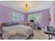 Cozy bedroom with two windows, soft purple walls, and a comfortable bed, complemented by desk and keyboard at 8206 Idlewild Rd # 22, Indian Trail, NC 28079