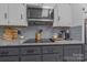 Close up on granite counter tops, glass cook top, microwave and gray subway tile backsplash at 8206 Idlewild Rd # 22, Indian Trail, NC 28079