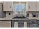 Close-up of the kitchen sink with updated faucet, granite countertops, and subway tile backsplash at 8206 Idlewild Rd # 22, Indian Trail, NC 28079