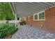 A covered patio area featuring a stone-patterned concrete floor and a partially visible brick exterior at 8206 Idlewild Rd # 22, Indian Trail, NC 28079