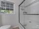 Modern tiled shower with a glass door and a window that provides natural light at 8206 Idlewild Rd # 22, Indian Trail, NC 28079