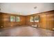 Bedroom featuring paneled walls and three windows, creating a cozy and unique atmosphere at 830 Cabaniss Dr, Shelby, NC 28150