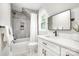 Bathroom featuring grey tiled shower/bath, white vanity and toilet and a modern rectangular mirror at 9527 Walkers Ferry Rd, Charlotte, NC 28214