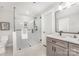 Bathroom with a glass enclosed shower and gray vanity with black hardware at 9527 Walkers Ferry Rd, Charlotte, NC 28214